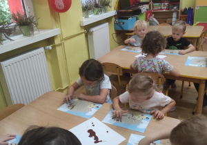 Dzieci malują palcami jeże.