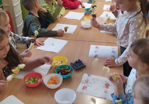 Dzieci przygotowują owocowe szaszłyki