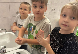Oliwier, Kuba S. i Olek myją ręce zgodnie z instrukcją