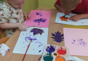 Dzieci malują liście farbami
