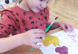 Dominika maluje farbami liście
