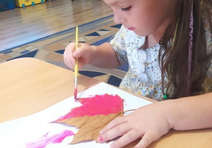 Lilianka maluje farbami liście