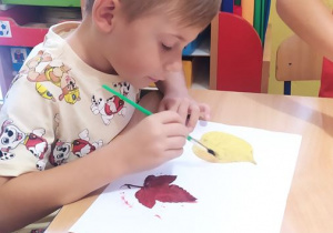Jasio maluje farbami liście