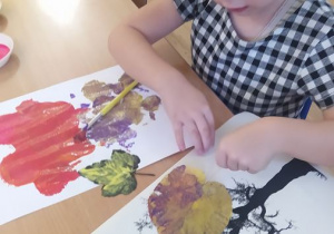 Amelka maluje farbami liście
