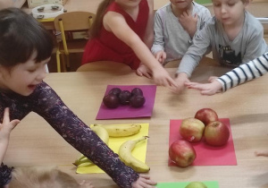 Dzieci segregują owoce wg. jednej cechy.