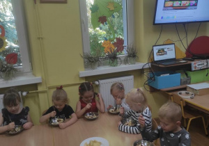 Dzieci zjadają wykonaną przez siebie sałatkę.
