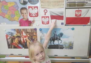 Zosia K. pokazuje flagę Polski.