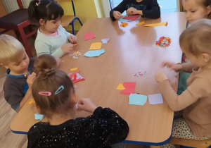 Dzieci robią wydzierankę z kolorowego papieru