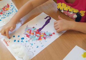 Dzieci robią kropelki deszczu maczając palec w farbie