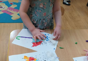 Dzieci robią kropelki deszczu paluszkiem umoczonym w farbie