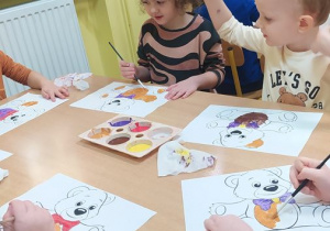 Dzieci wykonują pracę plastyczną z użyciem farb