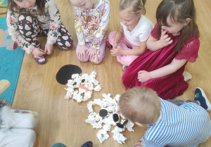 Dzieci układają bałwanka.