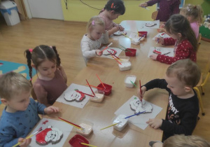 Dzieci malują lukrem Mikołaja z piernika.