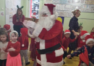 Dzieci tańczą ze Świętym Mikołajem.