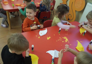 Dzieci przyklejają listki do jeżyka.