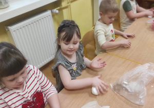 Dzieci formują kule z masy porcelanowej.