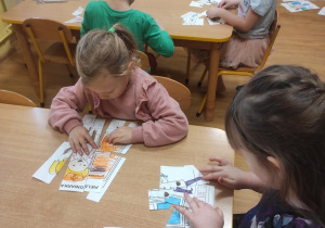Dzieci układają puzzle z zawodami.