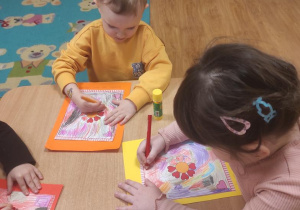 Dzieci kolorują serwetki dla babć.