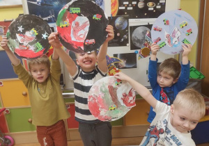 Chłopcy pokazują swoje wymyślone planety.