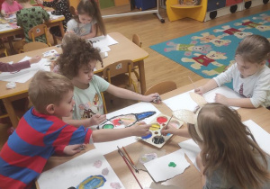 Dzieci malują ilustrację do wysłuchanej piosenki.
