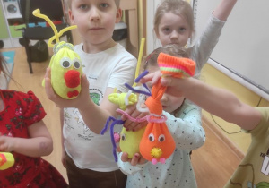 Dzieci pokazują swoje zabawki.