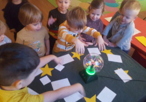 Dzieci stoją przy magicznej kuli.