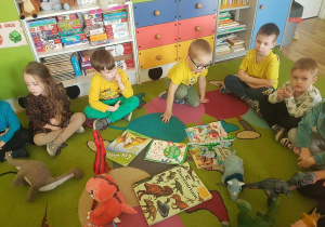 Książki i albumy o dinozaurach przyniesione do przedszkola przez dzieci.