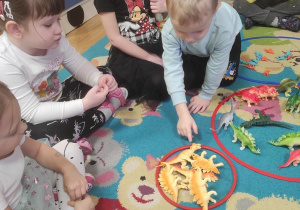 Zabawy matematyczne - dzieci segregują dinozaury i je przeliczają.