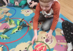 Zabawy matematyczne - dzieci segregują dinozaury i je przeliczają.