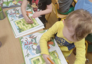 Dzieci rysują drogę dinozaura do jajek.