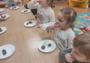 Dzieci zjadają kuleczki marcepanowe.
