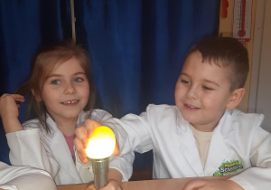 Zosia i Witek podświetlają jajko by sprawdzić co jest w środku.