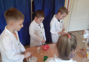 Szymon, Witek, Jaś i Nikola mieszają składniki masy balonowej.