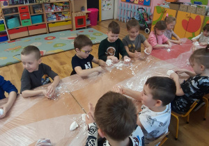 Dzieci z grupy podczas zabawy sztucznym śniegiem.