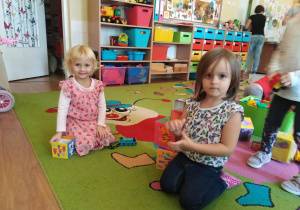 Nina i Amelka układają wieżę.