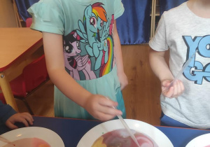 Dzieci dodają do mleka barwniki spożywcze i obserwują zjawisko mieszania barw.