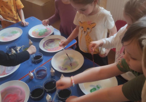 Dzieci dodają do mleka barwniki spożywcze i obserwują zjawisko mieszania barw.