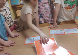 Dzieci układają historyjkę obrazkową o bocianach.