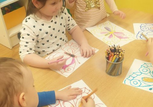 Dzieci wykonują pracę plastyczną "Motyla"