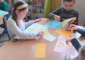 Dzieci wycinają nożyczkami paski z papieru