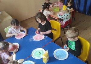 Dzieci barwią sól kolorową kredą.