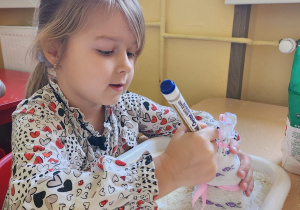 Maja maluje oczka królikowi.