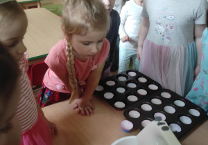 Dzieci obserwują jak wyrabiane jest ciasto.