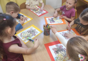 Dzieci kolorują babę wielkanocną i naklejają obrazki wg. instrukcji nauczyciela.