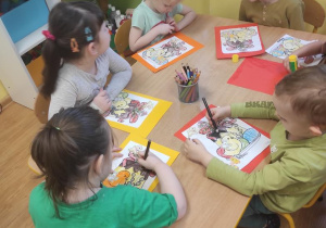 Dzieci kolorują babę wielkanocną i naklejają obrazki wg. instrukcji nauczyciela.