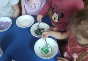 Dzieci mieszają jogurt z barwnikami.