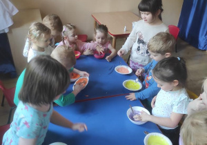Dzieci mieszają jogurt z barwnikami.