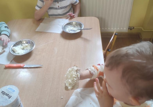 Dzieci zjadają wykonane kanapki z twarożkiem.