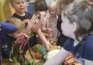 Dzieci oglądają, porównują i próbują warzywa.