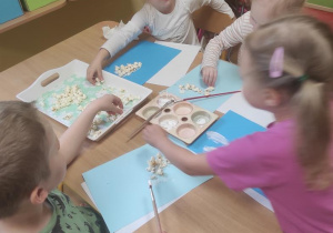 Dzieci przyklejają popcorn.